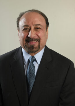 headshot of director, Paul Colletti, dressed in a suit and tie